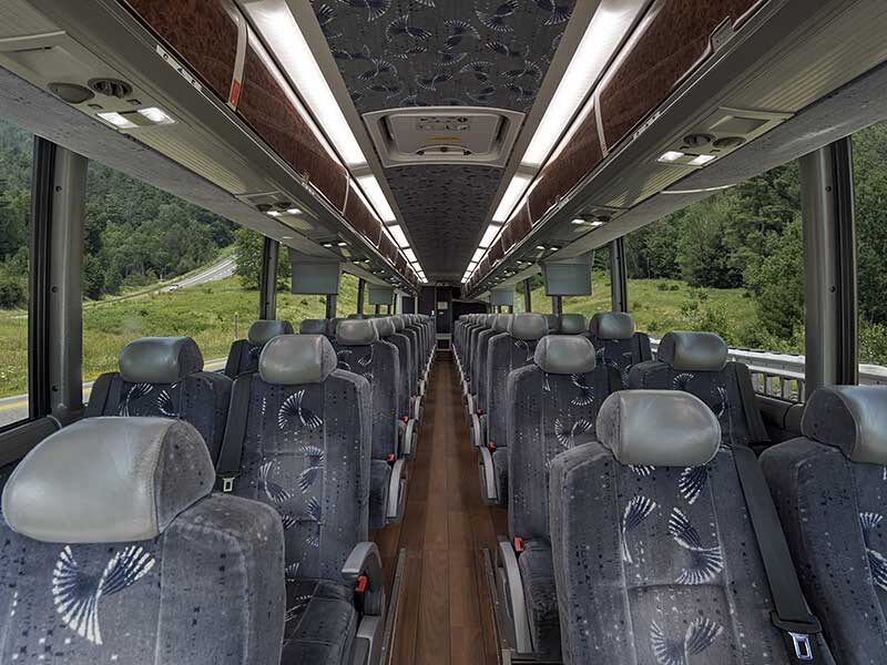 Photo showing the full length interior of an MCI J4500 coach with gray seating